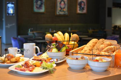 a table topped with plates of food and pastries at Aloft Stuttgart in Stuttgart