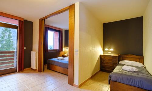 a small bedroom with a bed and a window at Forte Family Village - Azzurro Club in Sella Nevea