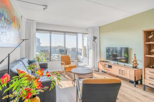a living room with a couch and a tv at Appartementencomplex Juliana 50 in De Koog