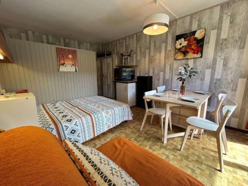 une chambre avec deux lits et une table et des chaises dans l'établissement Studio confortable, à 50m des pistes, pour 4 pers., parking, wifi, animaux admis - FR-1-525-273, à Saint-Étienne-en-Dévoluy