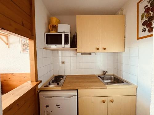 une petite cuisine avec un évier et un micro-ondes dans l'établissement Appartement pour 4 à Vallandry, accès direct aux pistes, balcon, animaux admis - FR-1-757-101, à Landry