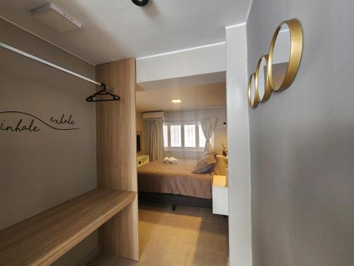 ein Schlafzimmer mit einem Bett und einem Spiegel an der Wand in der Unterkunft Emilio Jofré II - Departamento céntrico y luminoso in Villa Marini