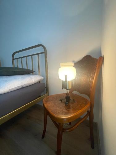 a table with a lamp on it next to a bed at Apartmán Bellevue in Boskovice