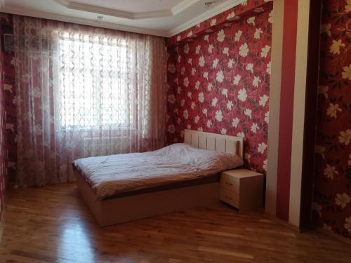 una piccola camera da letto con un letto e una finestra di Private Room in Shared Apartment a Baku