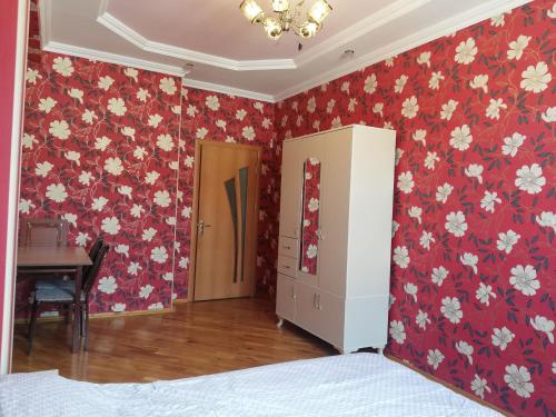 una camera da letto con carta da parati floreale rossa e bianca di Private Room in Shared Apartment a Baku