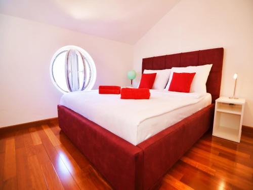 ein Schlafzimmer mit einem großen Bett mit roten Kissen in der Unterkunft Apartment in Murter with Pool and Sea Views in Murter