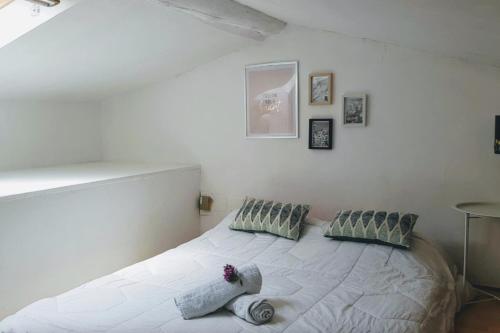 - une chambre avec un lit blanc et des oreillers dans l'établissement 25m duplex apartment in town center, à Aix-en-Provence