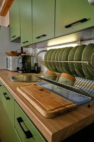 a kitchen with green cabinets and a sink and a cutting board at Пе́трови Вили in Ribarica