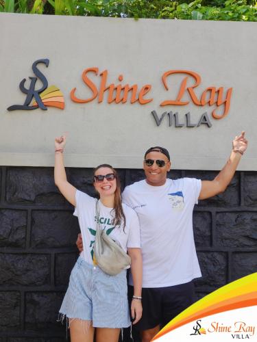 a man and a woman standing in front of a sign at Shine Ray VILLA in Galle