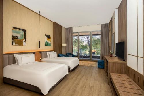 a hotel room with two beds and a television at Rixos Montaza Alexandria in Alexandria