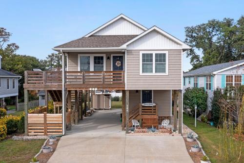 a house with a wrap around deck at OBX Beach Gnome in Kill Devil Hills