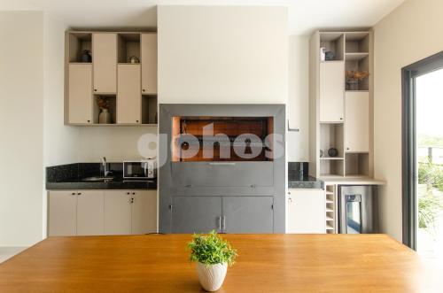 a kitchen with white cabinets and a wooden table at Luxe 2 Bedroom Apt In The Heart Of Villa Morra in Asuncion