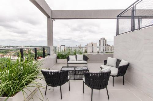 a patio with chairs and a table on a balcony at Luxe 2 Bedroom Apt In The Heart Of Villa Morra in Asuncion