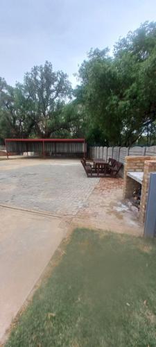 a picnic table and benches in a park at Ammigos Guesthouse in Klerksdorp