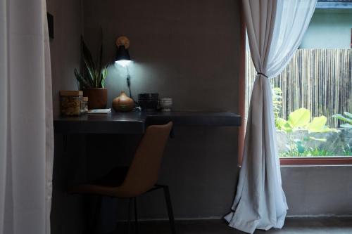 a desk with a chair next to a window at Inigtan Lio Villas in El Nido