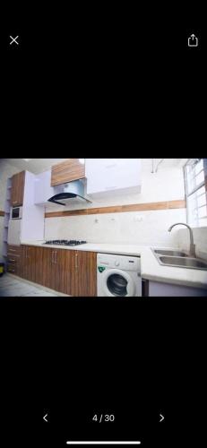 a kitchen with a sink and a washing machine at Oasis Villa Lekki in Lekki