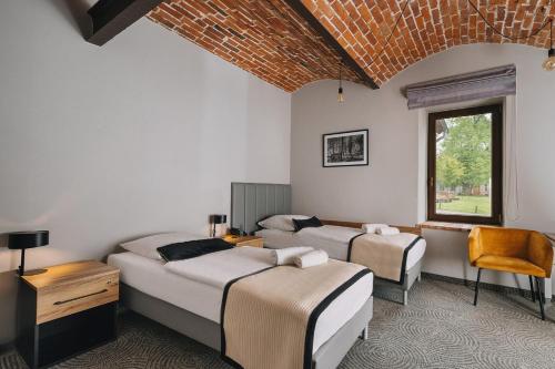 a bedroom with two beds and a window at Dwór Kolesin in Nowe Kramsko