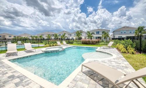 a swimming pool with chairs in a yard at Captivating 5 Bdrm Villa with Theater at Encore in Orlando