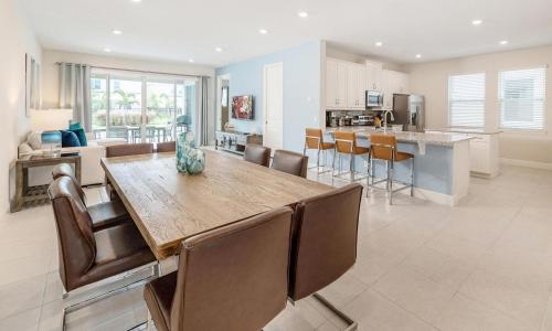a kitchen and living room with a wooden table and chairs at Captivating 5 Bdrm Villa with Theater at Encore in Orlando