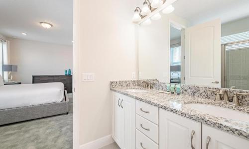 a bathroom with a sink and a bed in a room at Captivating 5 Bdrm Villa with Theater at Encore in Orlando