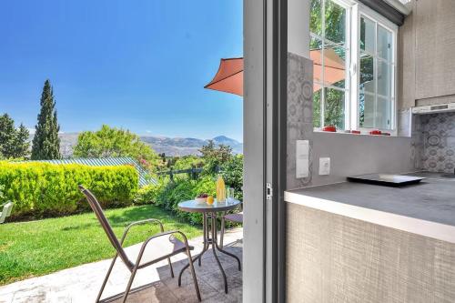 a patio with a table and chairs and a window at Paradiso Verde in Lixouri