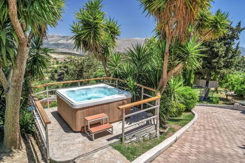 a hot tub in a garden with palm trees at Paradiso Verde in Lixouri