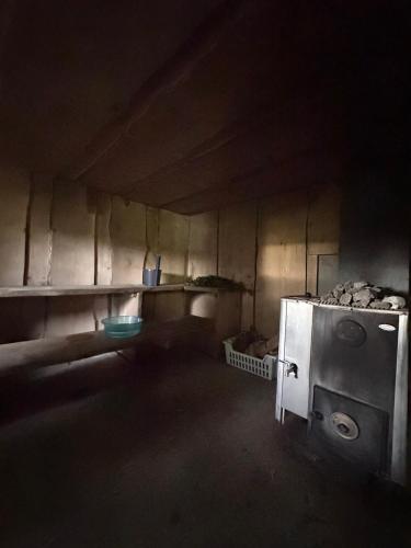 a kitchen with an oven in a dark room at Omakotitalo Haapavesi Mieluskylä in Ollilanperä
