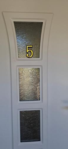 a white door with a window with the number at Vila Jovana in Vrdnik