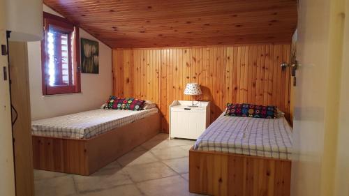 ジャルディーニ・ナクソスにあるCasa Dianaのベッド2台 木製の壁の部屋
