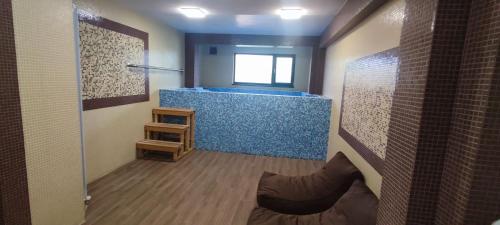 a bathroom with a shower with a blue tub at Hotel Dumanov in Bansko