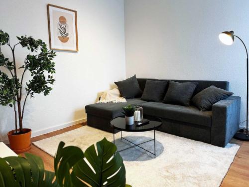 a living room with a couch and a table at 60qm Apartment in Viersen zentral gelegen mit hohen Decken - BEUYS Apartments - Viersen in Viersen