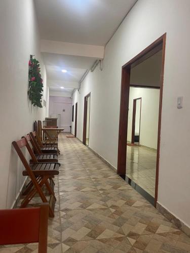 a hallway with chairs and tables and a hallway with a door at Villa Brilho do Sol Jeri in Jericoacoara