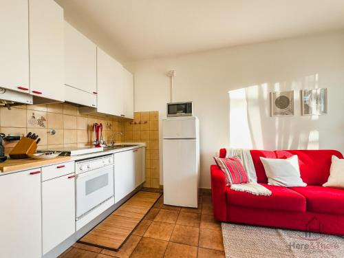 a kitchen with a red couch in a kitchen at Ceriale for Fun - AquaPark & Beaches 5min - AC in Ceriale
