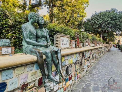 a statue of two people sitting on a wall at Ceriale for Fun - AquaPark & Beaches 5min - AC in Ceriale