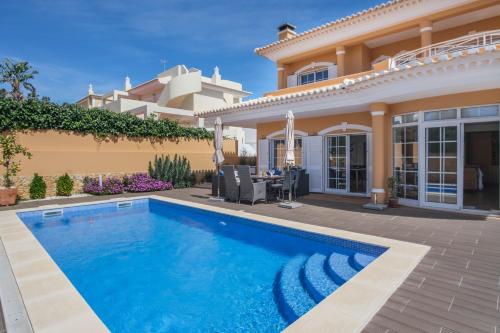 a villa with a swimming pool in front of a house at Canto do Sol, 4 Bedroom Villa in Lagos