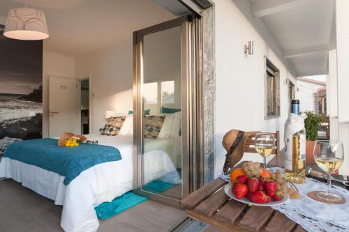 a bedroom with a bed and a table with a bowl of fruit at Beachouse - Surf, Bed & Breakfast in Ericeira