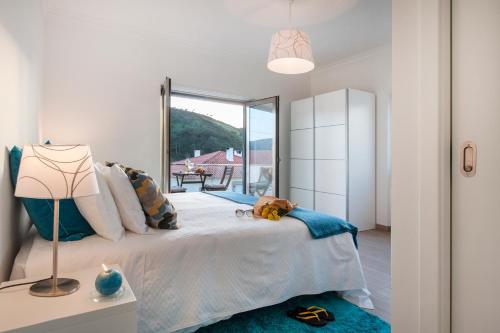 a bedroom with a bed and a large window at Beachouse - Surf, Bed & Breakfast in Ericeira
