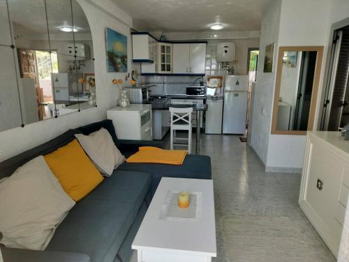 a living room with a blue couch and a kitchen at Puerto Rico Apartment Terrace Gran Canaria in Puerto Rico de Gran Canaria