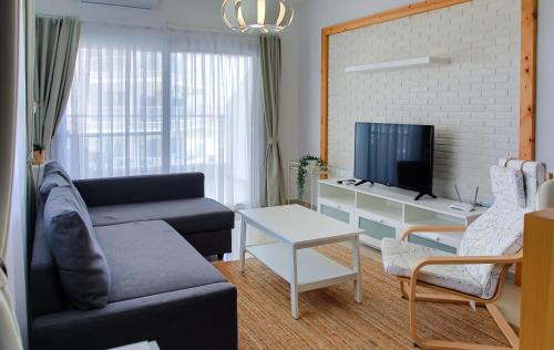 un salon avec un canapé et une télévision dans l'établissement One Bedroom Apartment in Caesar Resort & SPA, Long Beach, à Perivolia tou Trikomou