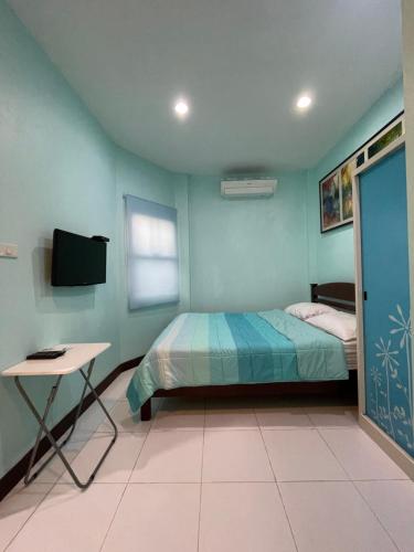 a bedroom with a bed and a desk and a television at Phuket Best Travel in Nai Yang Beach