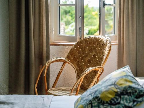 two wicker chairs sitting in front of a window at Logis Hôtel La Ferme de Flaran in Maignaut