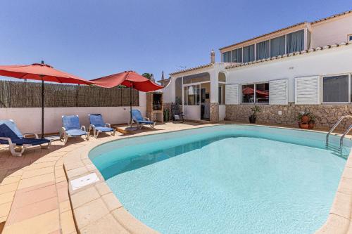 a swimming pool with two chairs and a house at Chilling In Lagos House Retreat by Algarve Golden Properties in Lagos