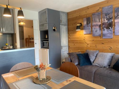 un salon avec un canapé et une table dans l'établissement LaGodille Pra Loup 1500, à Pra-Loup