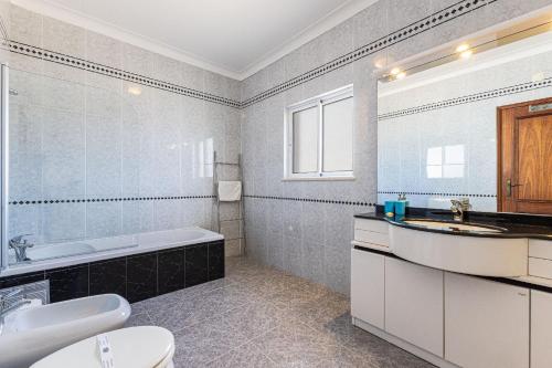 a bathroom with a sink and a tub and a toilet at Chilling In Lagos House Retreat by Algarve Golden Properties in Lagos