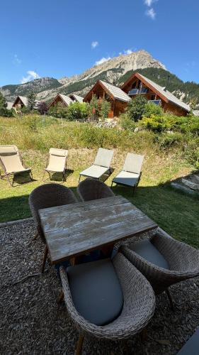 a wooden table and chairs and a table and chairs at Un Brin Cosy in Névache