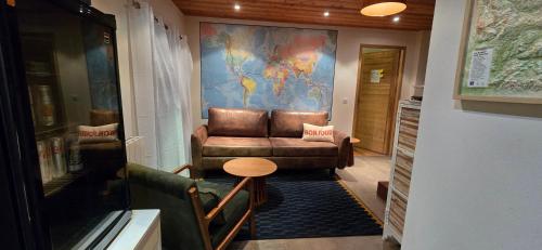 a living room with a leather couch and a table at Papillon 05 - Wellness in Briançon