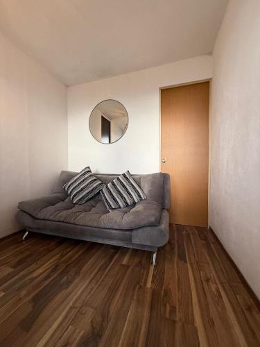 a couch in a living room with a mirror at Metepec in Toluca
