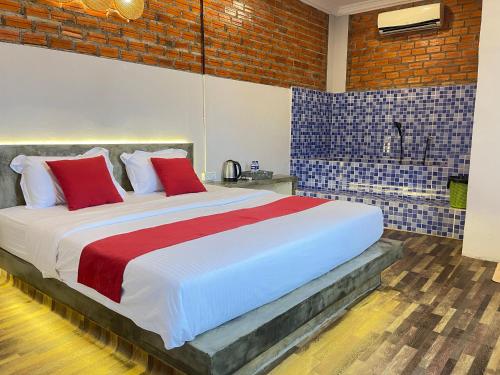 a bedroom with a large bed with red pillows at The Last Beach House in Kampot