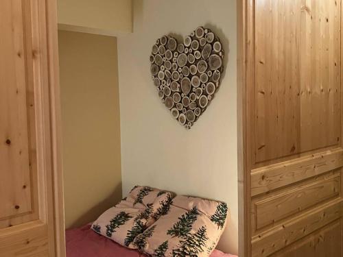 un cœur suspendu sur un mur à côté d'un lit dans l'établissement Appartement rénové 3 couchages, ski aux pieds - FR-1-292-217, à Isola