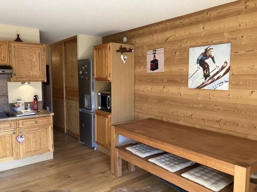 - une cuisine avec un mur en bois et un banc dans l'établissement Appartement rénové 3 couchages, ski aux pieds - FR-1-292-217, à Isola
